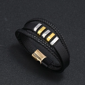 Detalle de pulsera de cuero multicapa con cubos de metal oro y plata y cierre magnético fuerte