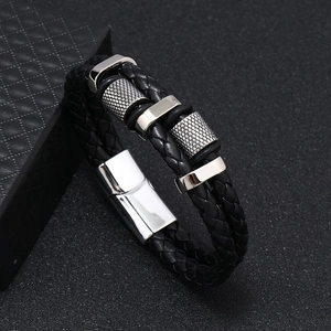 Detailed macro view of black braided leather men's bracelet with steel magnetic clasp