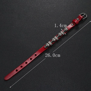 Detail view of 26cm red punk leather bracelet with five metal skull studs and buckle closure