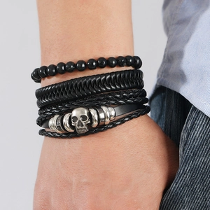 Detailed view of multilayer men's leather bracelets with skull charms and woven textures