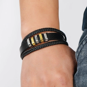 Primer plano de pulsera de cuero negro trenzado multicapa con detalles de metal mixto