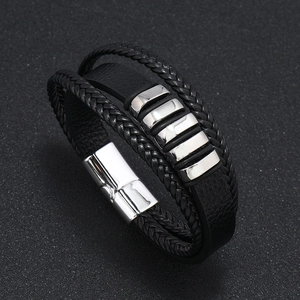Detalle de pulsera de cuero trenzado multicapa con cierre magnético de acero pulido