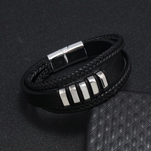 Detalle de la pulsera de cuero negro multicapa con acentos metálicos pulidos en plata