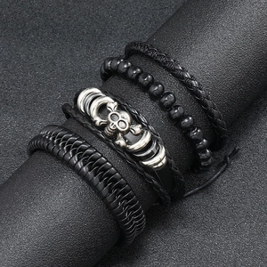 Detail view of 4-piece vintage leather bracelet set with silver skull charm on a stand