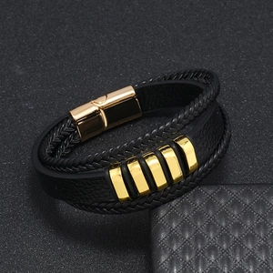 Detalle de la pulsera multicapa de cuero negro para hombre con cierre magnético dorado