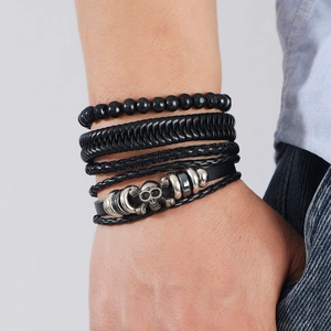 Detailed close-up of multilayer leather bracelet with silver skull charm and black beads