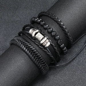Detail of vintage multilayer braided leather bracelets with black beads and metal charms