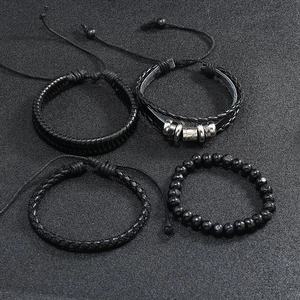 Macro detail of a 4-piece set of men's vintage multi-layer black braided leather bracelets