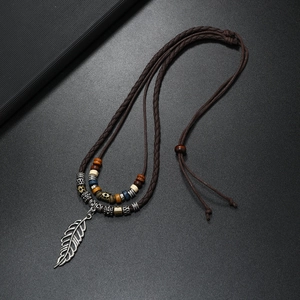 Vintage layered feather pendant necklace with dark brown cords and ethnic beads