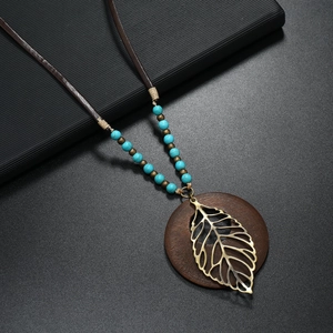 Collana boho vintage con pendente a foglia cava e disco in legno su cordoncino di cuoio