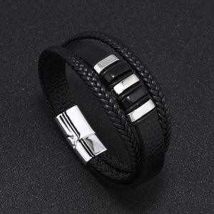 Primer plano detallado de pulsera multicapa de cuero negro trenzado para hombre con cierre imán