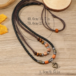 Detail of bohemian multilayer woven necklace with bronze heart pendant and beads