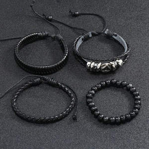 Detail view of 4-piece black leather braided bracelet set with metal accents and beads