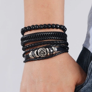 Close-up of multilayer leather bracelet with black beads and silver metal Ace of Spades charm