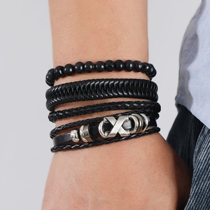 Macro detail of men's layered leather bracelet featuring vintage matte silver X-metal buckle