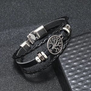 Close-up of multilayer leather bracelet with silver tree of life charm and magnetic clasp