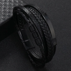 Detail view of multi-layer black braided leather bracelet with matte metal magnetic clasp