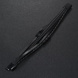 Detail view of multi-layer black braided leather men's bracelet with magnetic metal clasp