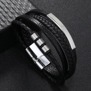 Detail of multi-layer black braided leather bracelet with silver magnetic buckle and metal ring
