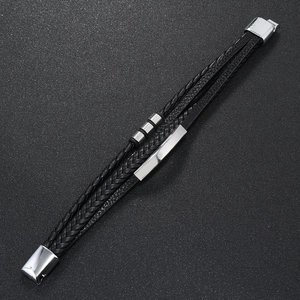 Detail of multi-layer black leather bracelet featuring a silver magnetic clasp and metal plates