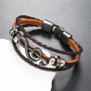 Detail of vintage multilayer leather bracelet featuring musical note and metal beads