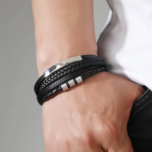 Close-up of multilayer black leather bracelet with silver magnetic clasp on male wrist