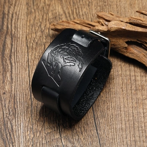 Retro black leather wolf head bracelet with silver metal buckle on a rustic wood background