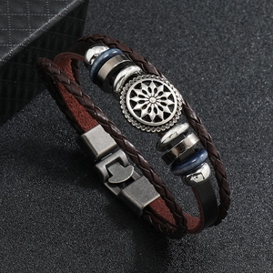 Detail view of vintage multi-layer leather bracelet with metal sunflower charm and clasp