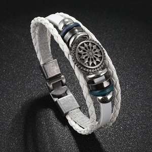 Detail of white braided leather bracelet with vintage sunflower metal charm and beads