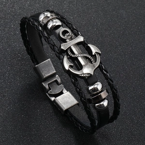 Detailed close-up of a vintage leather anchor bracelet with retro metal clasp and woven rope