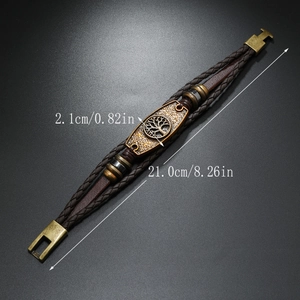 Detail showing the bronze tree of life charm and braided leather layers of the bracelet
