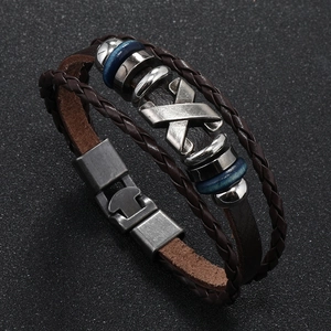 Detailed close-up of multilayer punk leather bracelet with vintage metal charms and X-symbol