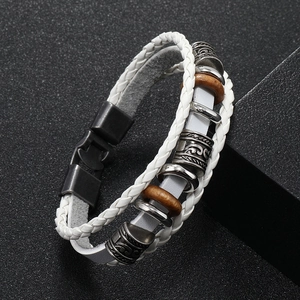 Detail of white braided leather bracelet with vintage metal beads and black magnetic clasp
