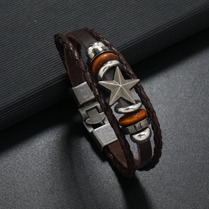 Macro detail of multi-layer leather punk bracelet with wooden beads and star pendant