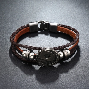 Close-up of brown multilayer leather bracelet featuring silver spade card charms with metal clasp