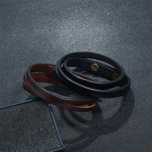 Detail view of double-wrap leather bracelets with vintage screw fasteners in black and brown