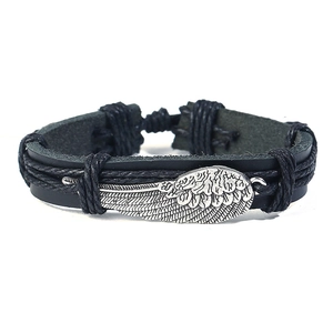 Detail of hand-woven black leather bracelet with vintage silver feather wing charm