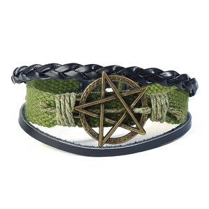 Detail of vintage multilayer men's leather bracelet with a bronze metal star pendant
