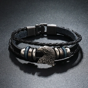 Detail of multi-layer leather bracelet with vintage eagle charm and metallic clasp