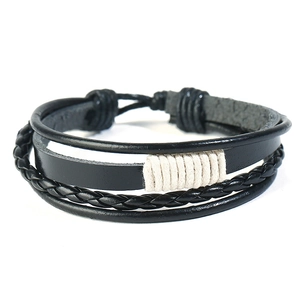 Detailed close-up of multilayer black leather bracelet with braided cord and cotton twine wrap