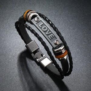 Close-up of multilayer punk leather bracelet with engraved LOVE metal plate and buckle