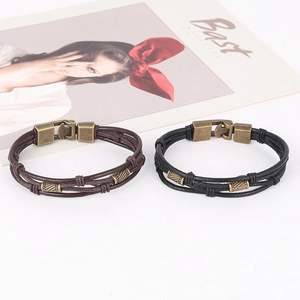 Detalle de las pulseras vintage de cuero trenzado en negro y marrón con cuentas metálicas