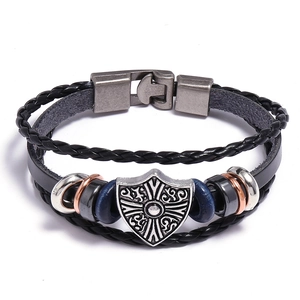 Close-up of vintage leather bracelet showing Celtic shield charm and magnetic clasp