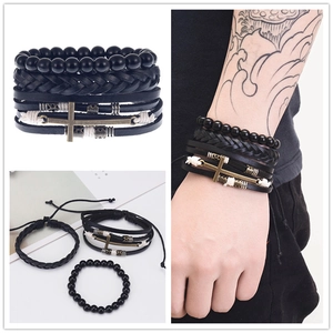 Detail of vintage woven leather bracelets set for men featuring a bronze cross charm pendant