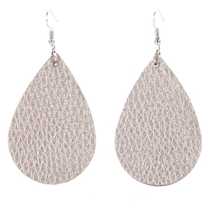Macro detail of teardrop faux leather earrings with champagne gold litchi texture
