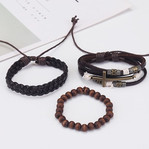 Detail of men's vintage leather bracelet set with bronze cross and wooden beads