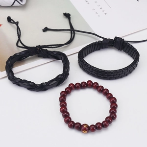 Close-up of men's vintage braided leather bracelet set with red wooden prayer beads