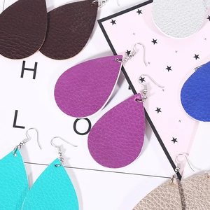 Detailed macro view of colorful teardrop faux leather earrings with litchi texture finish