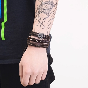 Detailed view of multilayer leather bracelet with Tree of Life charm and braided cord