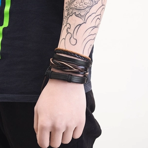 Detail of multi-layer braided leather bracelets in black and brown with vintage style